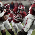 Justice Haynes carries the ball for Alabama against Auburn.