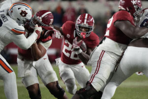 Justice Haynes carries the ball for Alabama against Auburn.