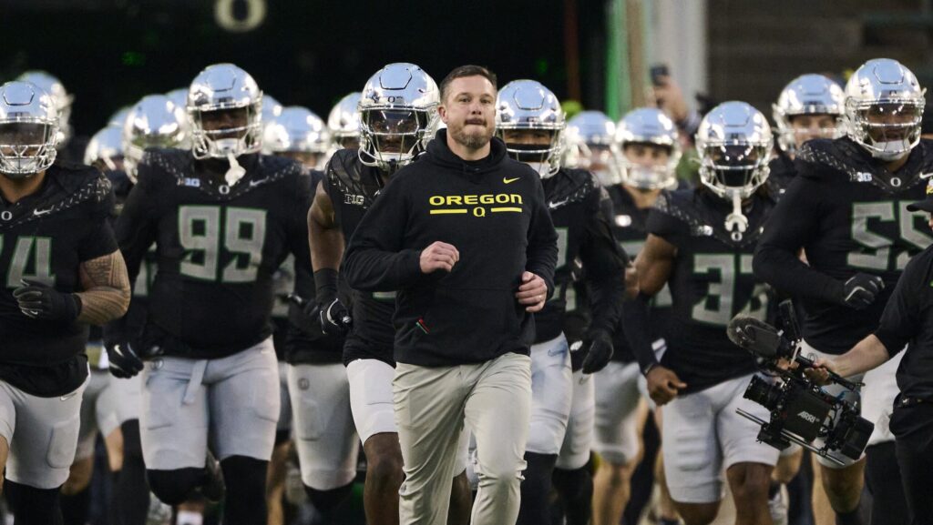 Dan Lanning leads Oregon out of the tunnel.