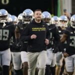 Dan Lanning leads Oregon out of the tunnel.