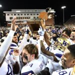 Washington players celebrate with the Apple Cup.