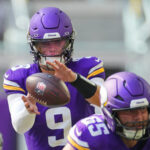 JJ McCarthy receives a snap.