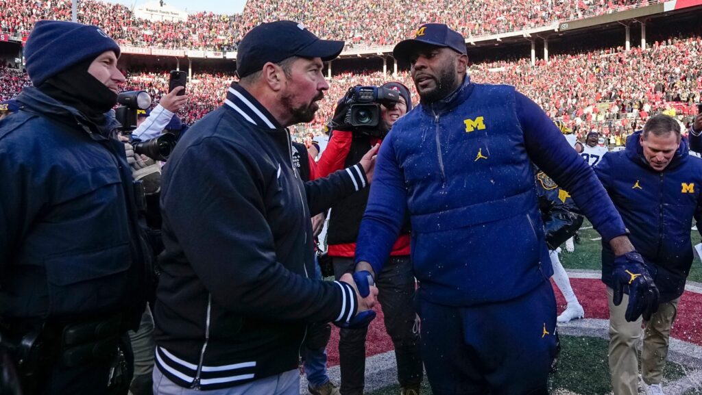 Ryan Day and Sherrone Moore shake hands.