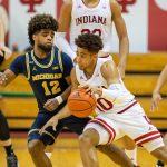Rob Phinisee dribbles the ball while Michigan Wolverines guard Mike Smith defends