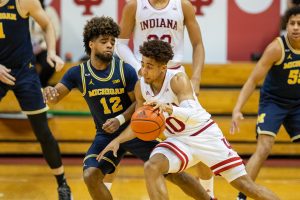 Rob Phinisee dribbles the ball while Michigan Wolverines guard Mike Smith defends