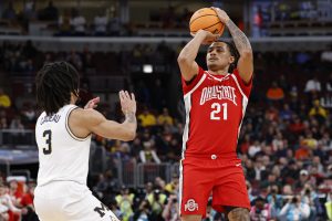 Devin Royal shoots against Michigan Wolverines guard Elliot Cadeau.