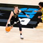 Fletcher Loyer dribbles as Michigan Wolverines guard Elliot Cadeau.