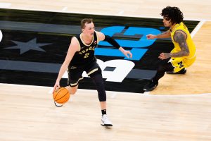 Fletcher Loyer dribbles as Michigan Wolverines guard Elliot Cadeau.