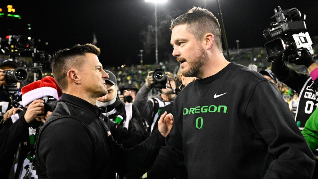 Dan Lanning and Bob Chesney shake hands.