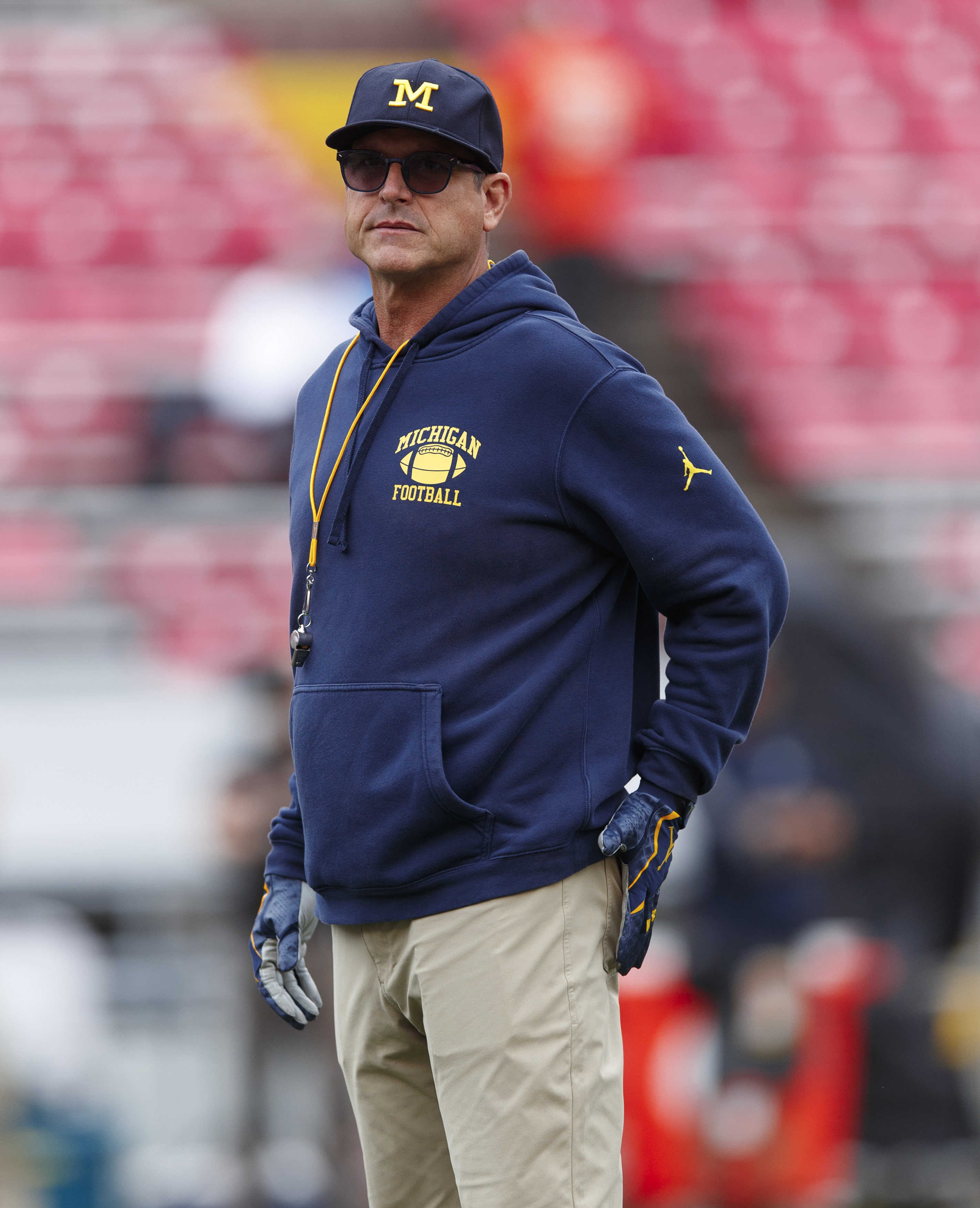 Harbaugh standing on the field during a Michigan game.