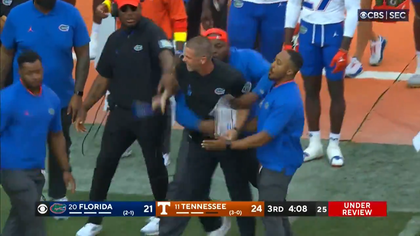 Billy Napier, Florida head coach, restrained by multiple assistants